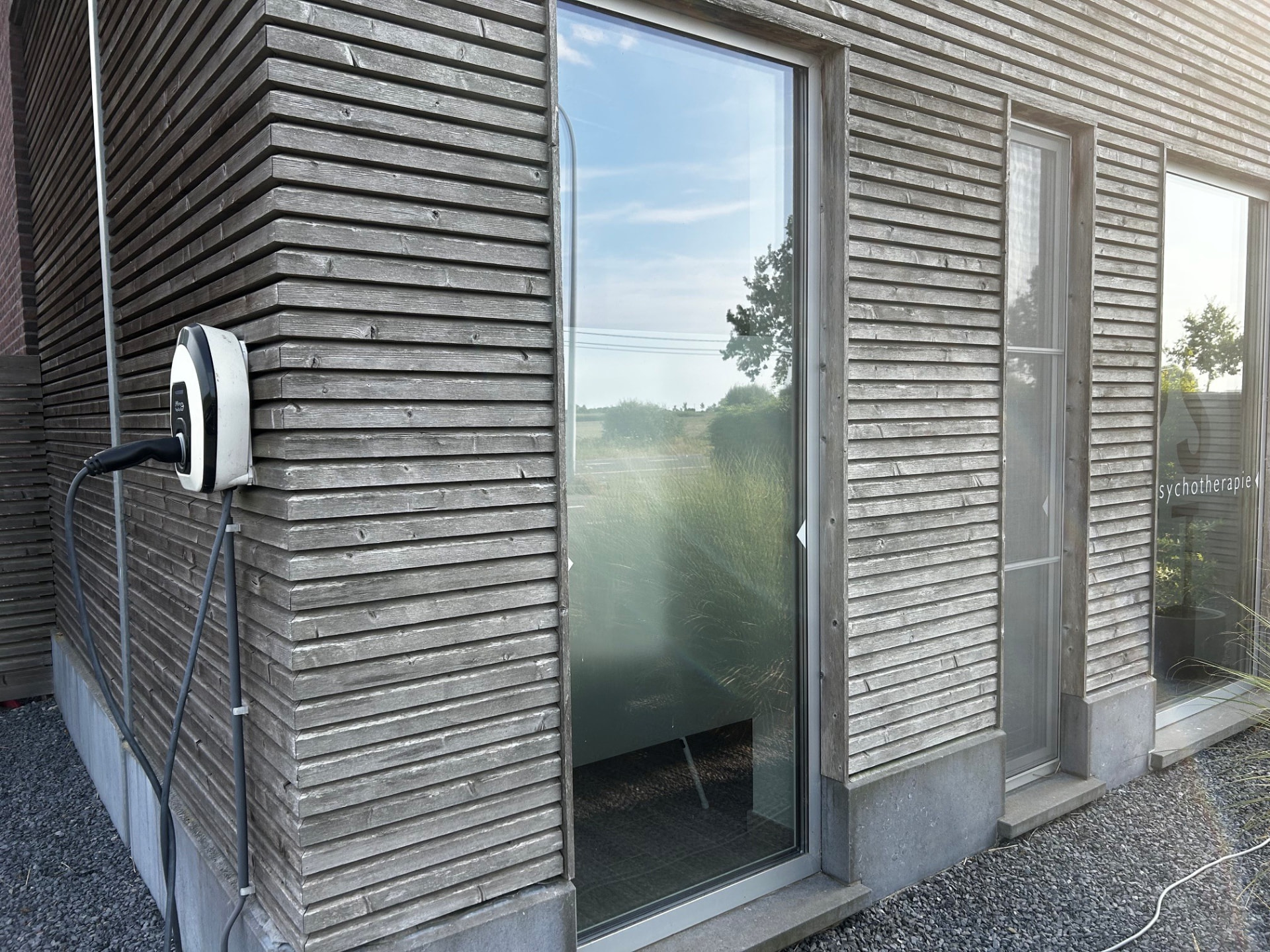 Laadpaal voor elektrische wagens aan de gevel van de praktijk